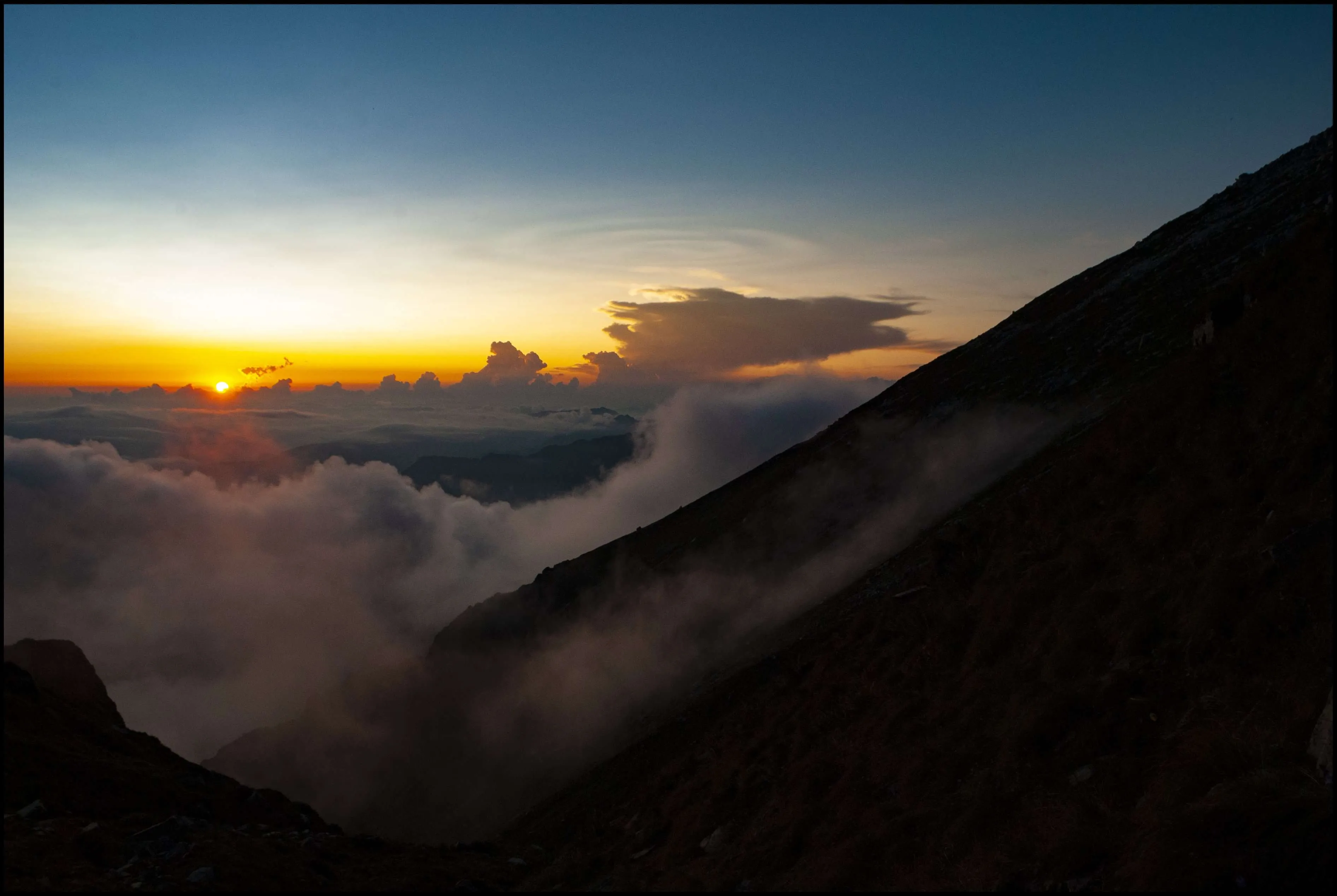 Cloudy sunset from mountains near Asurbag Top, Great Himalayan National Park, Himachal Pradesh, India